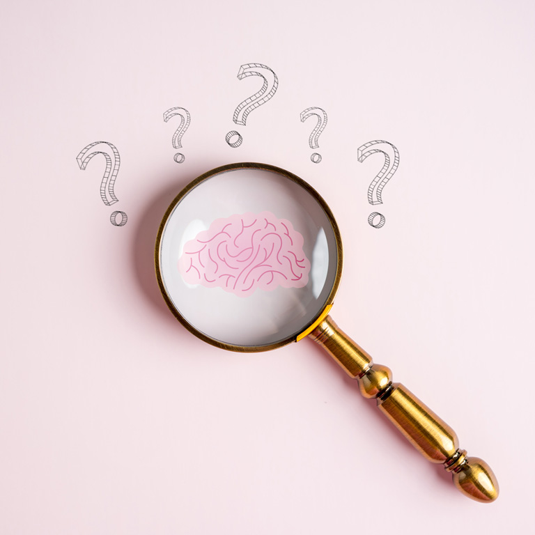 magnifying glass surrounded by question marks focused on illustrated brain